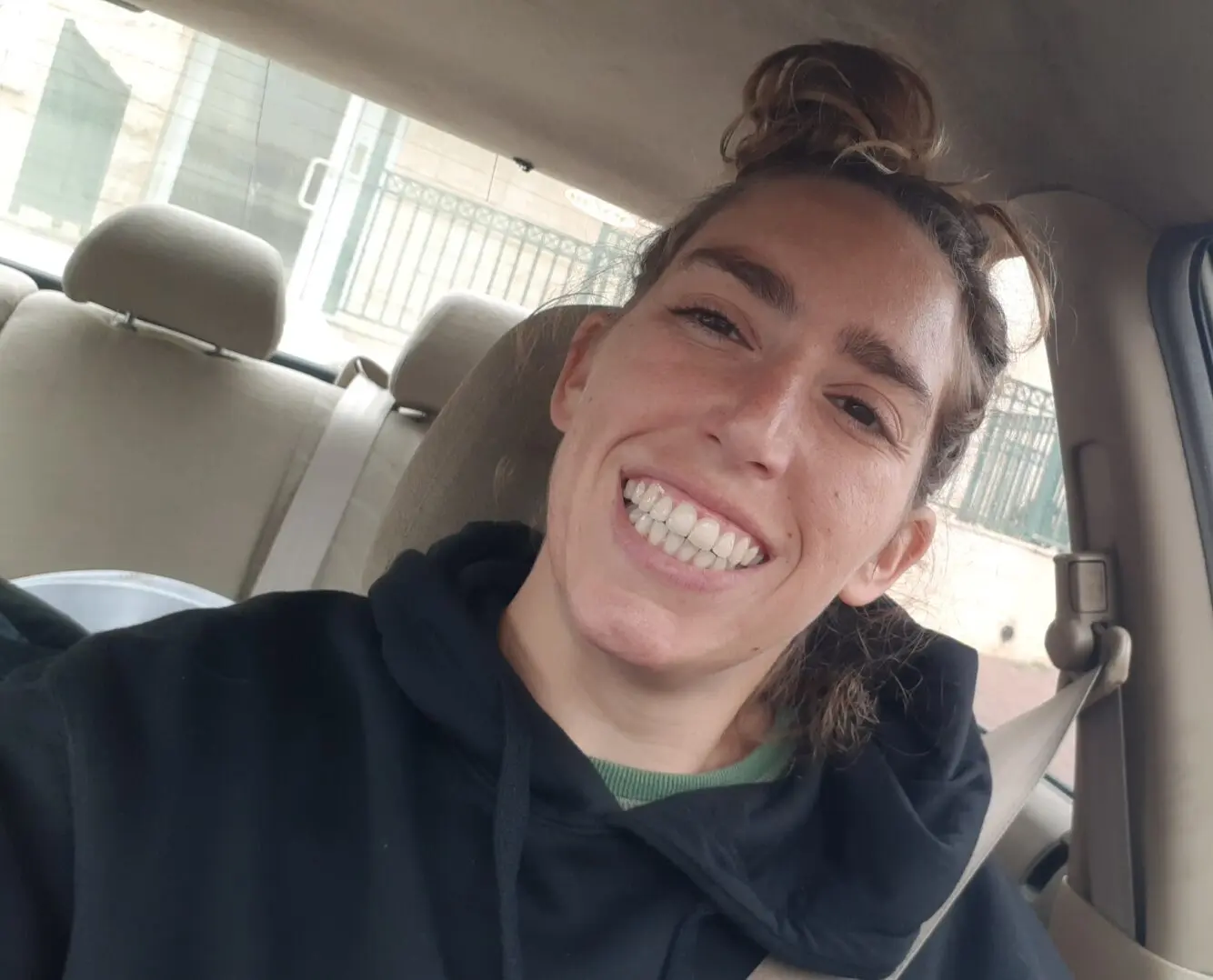 A woman in a car, smiling widely