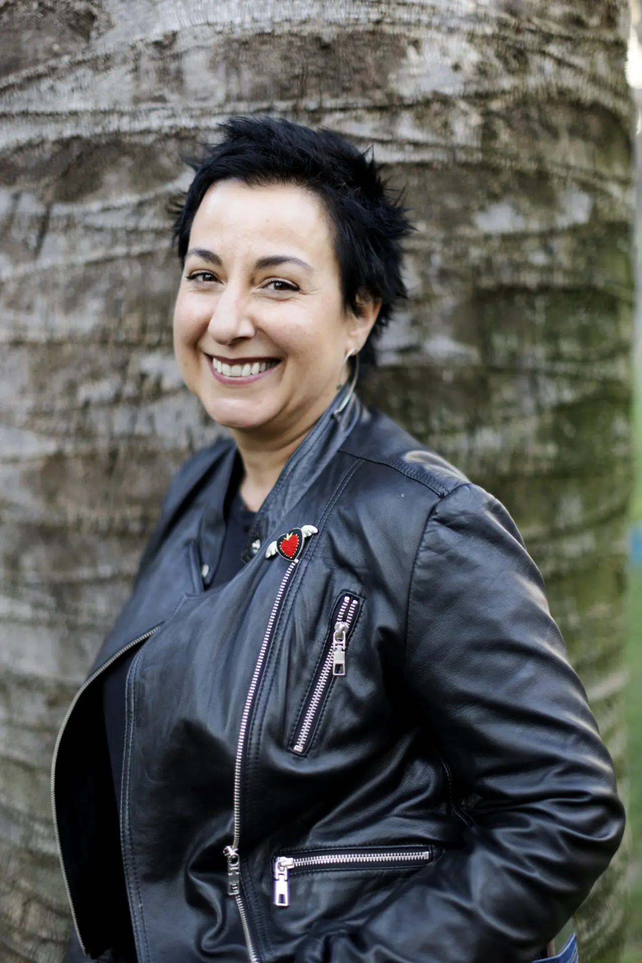 Photo of a woman with short black hair wearing a black leather jacket.